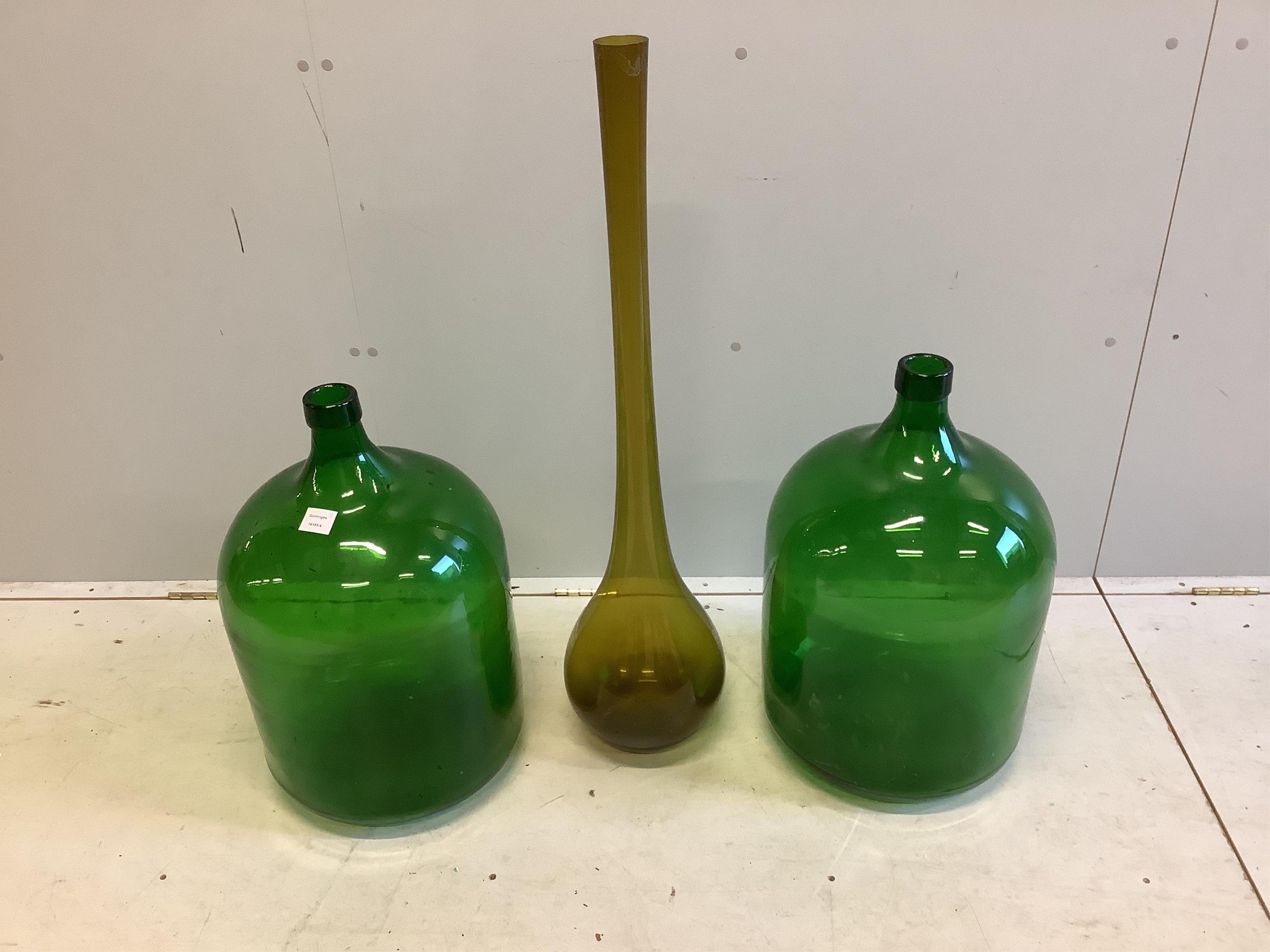 A pair of large green glass carboys, height 60cm together with a tall glass vase. Condition - fair to good